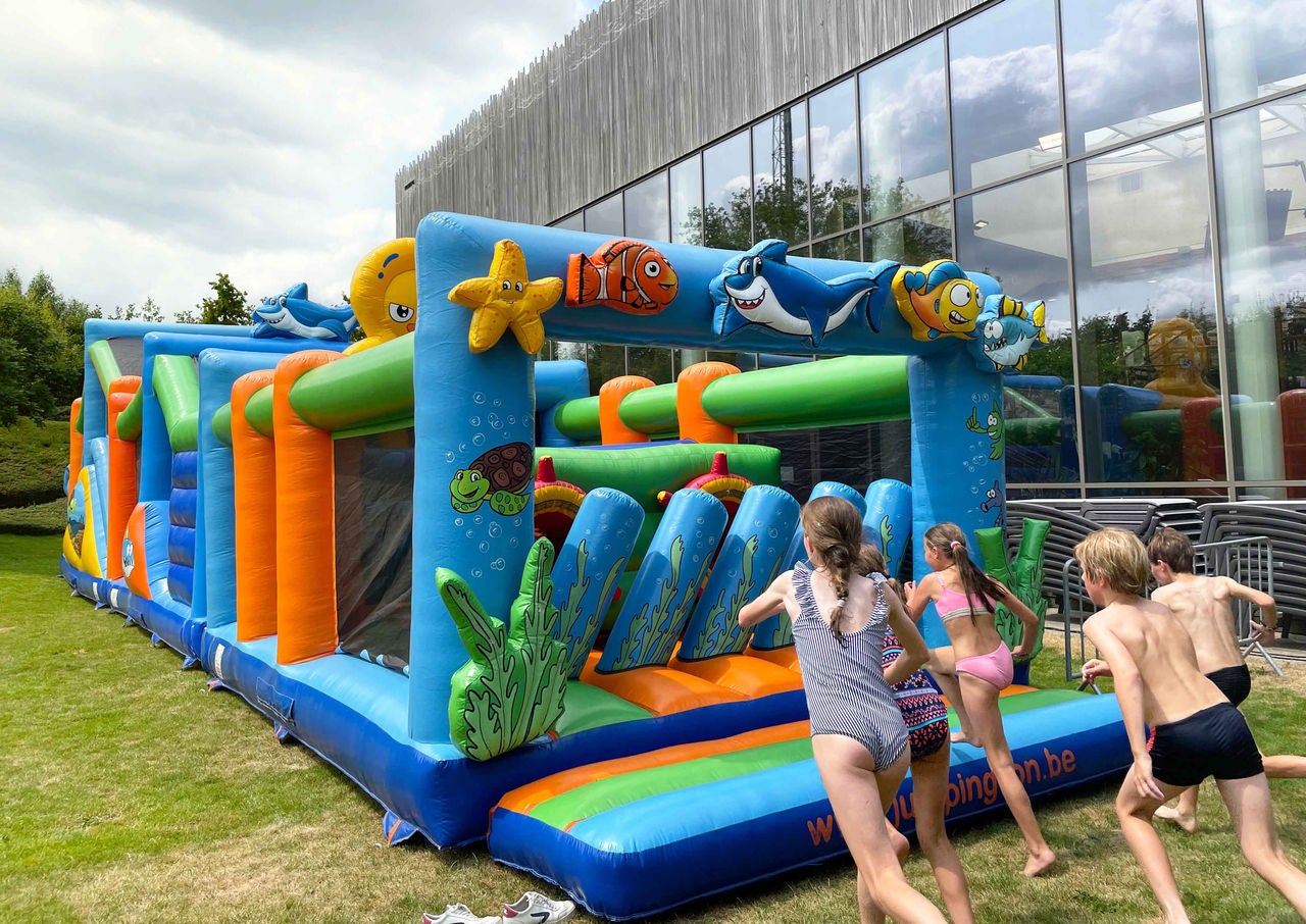 Kinderen rennen naar het springkasteel.