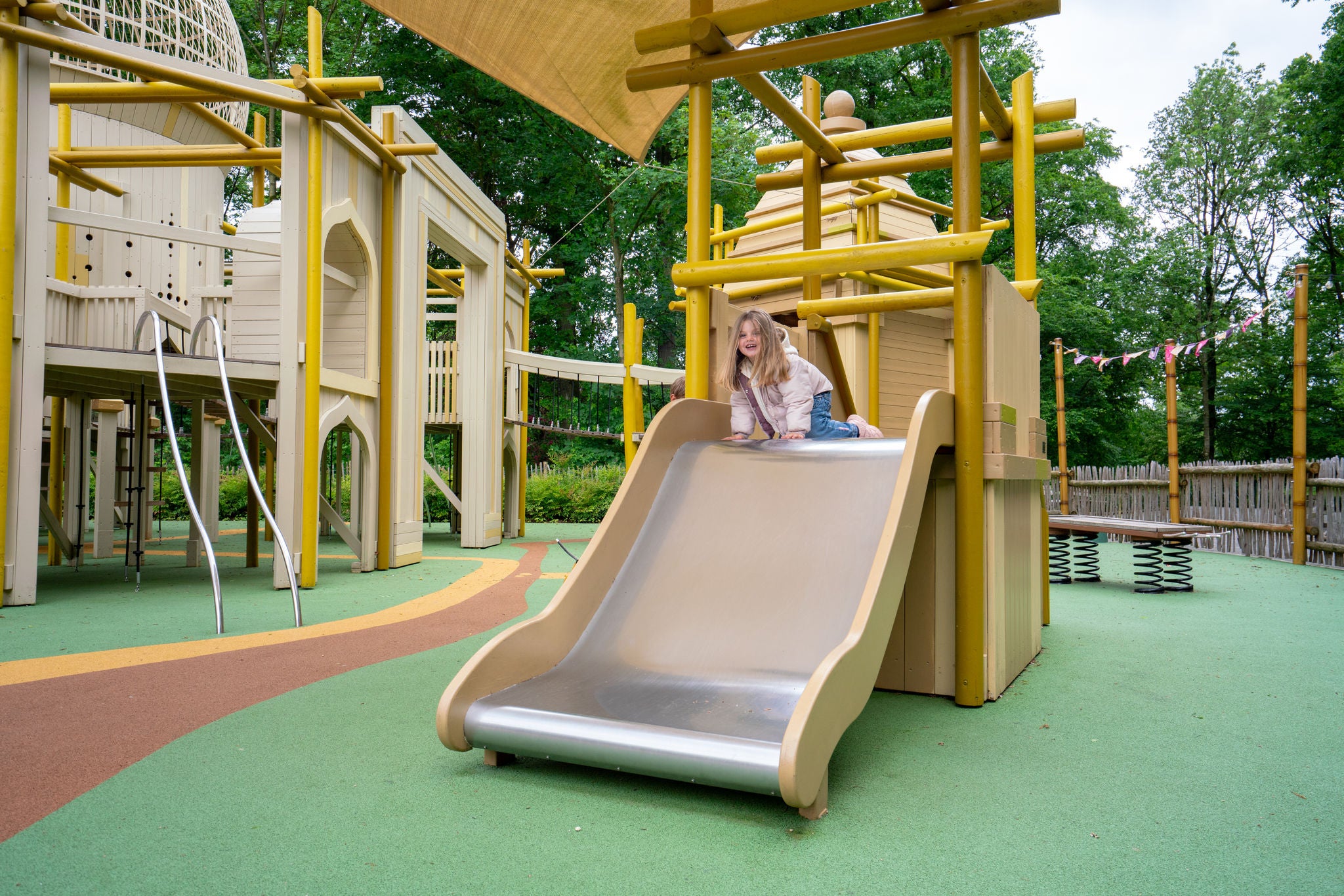 Meisje glijdt van een glijbaan van Hampi Playground.