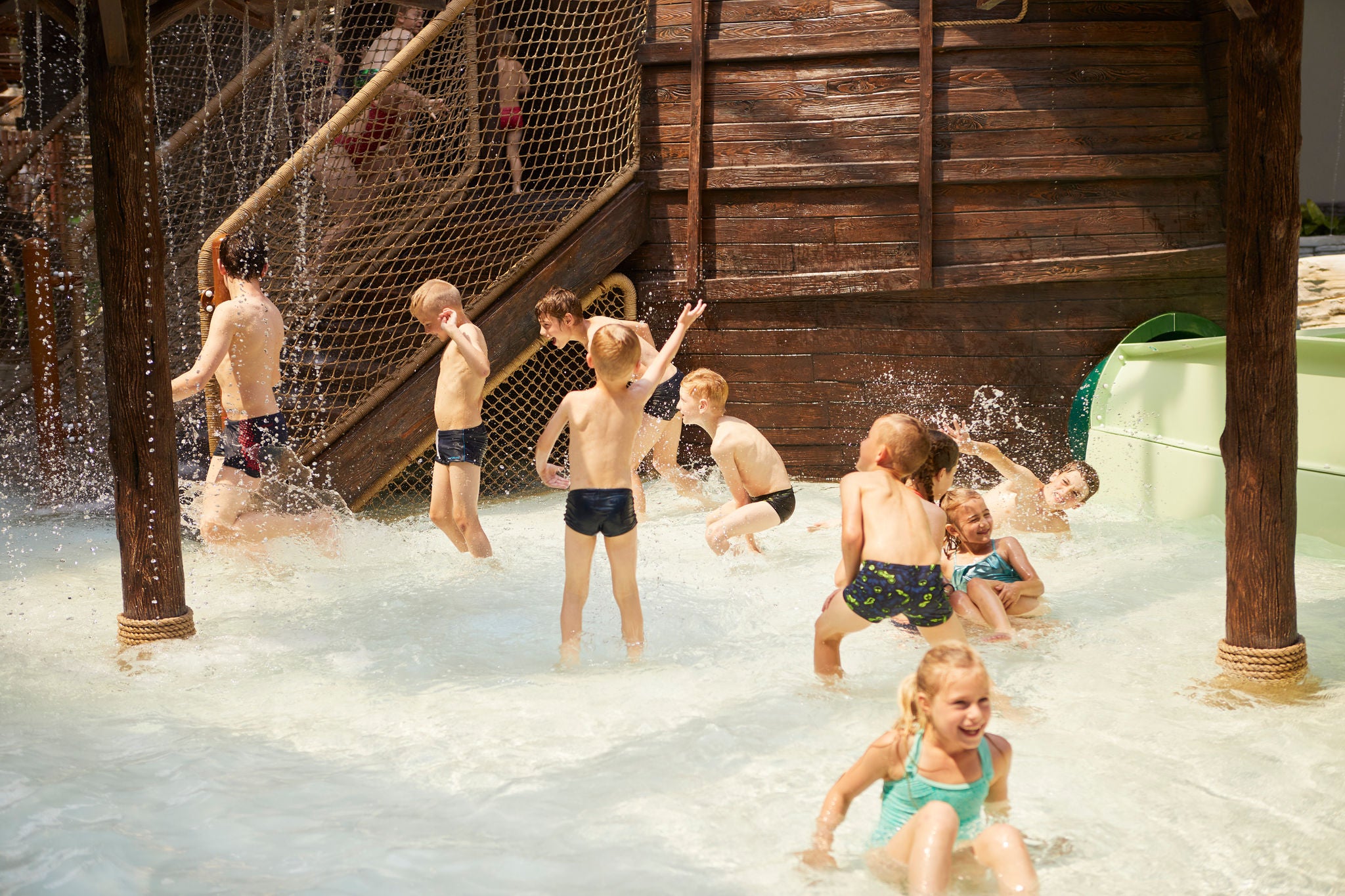 Kinderen spelen naast de Junior Explorer boot.