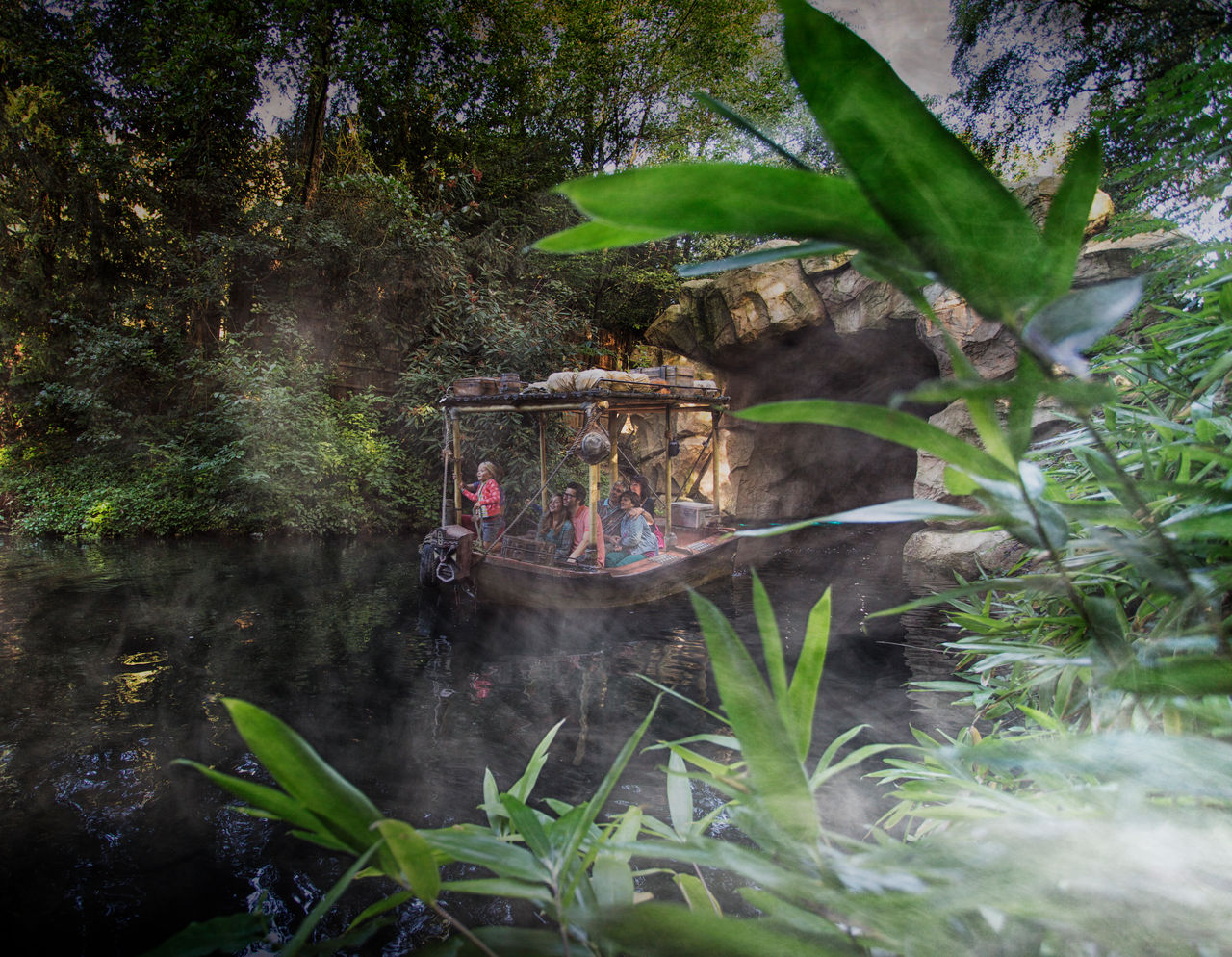 Familie vaart met een boot uit de grot van Jungle Mission.