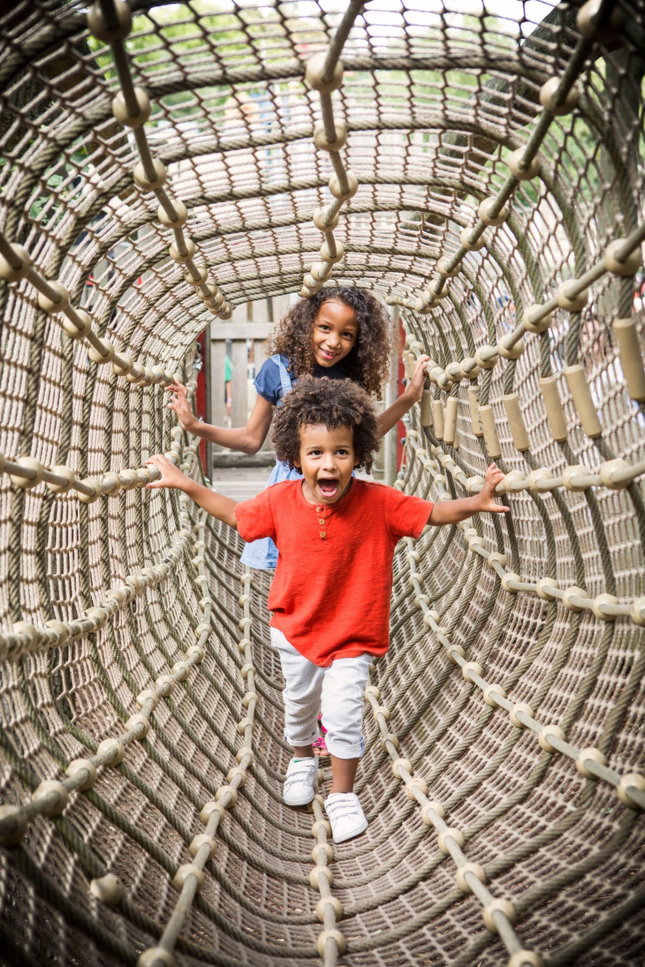 Broer en zus lopen door een tunnel net van het Palendorp.